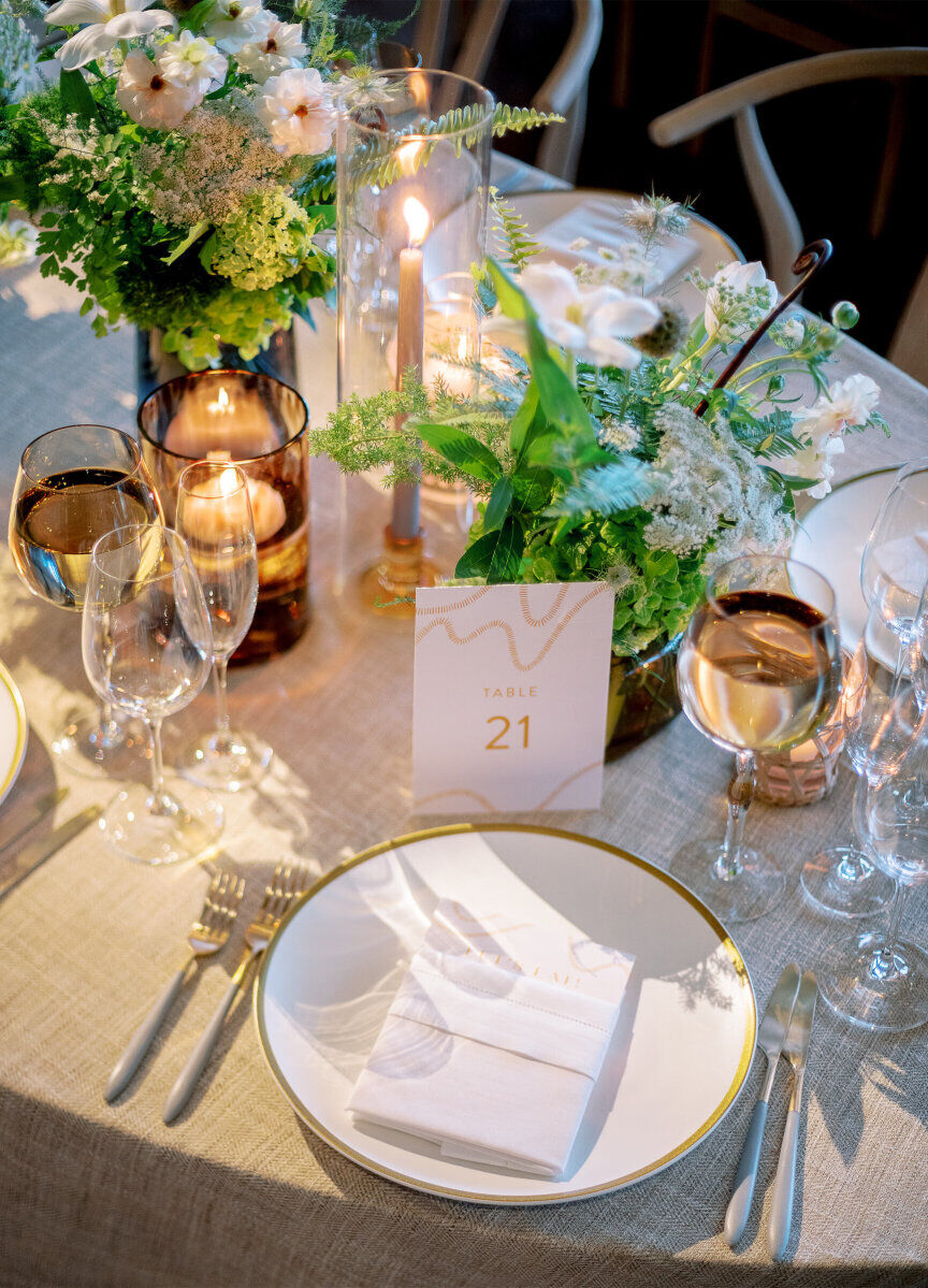 Modern plates and flatware were used at each place setting of this enchanted waterfront wedding.