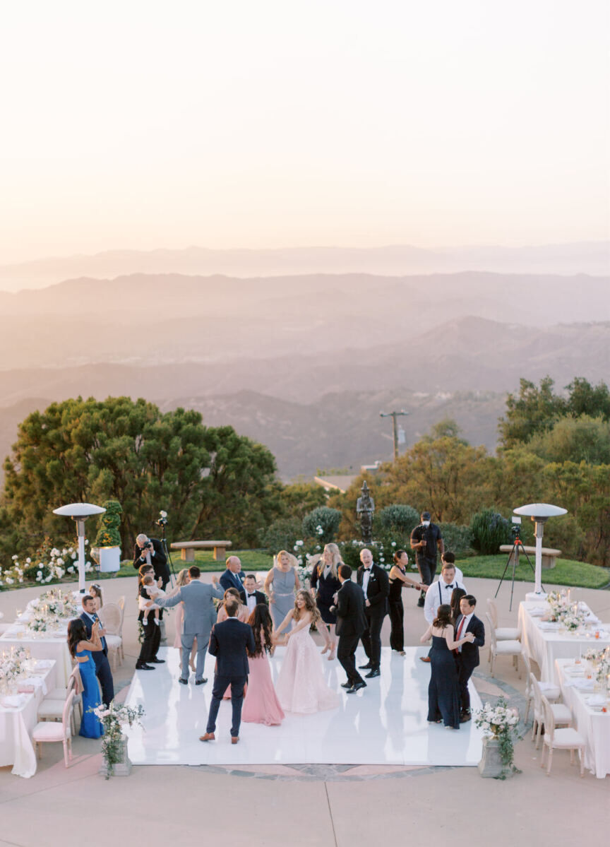 Guests dance on an outdoor dance floor at an estate wedding in Malibu, California.