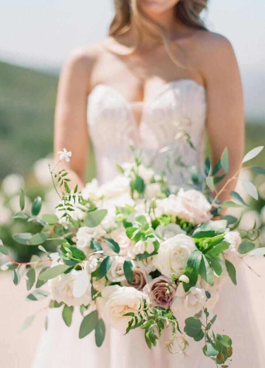 An organic bouquet of white and dusty mauve flowers paired with loose greenery.