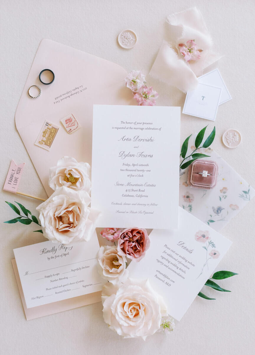 Wedding stationery with floral illustrations, a classic script font, and pink envelopes.
