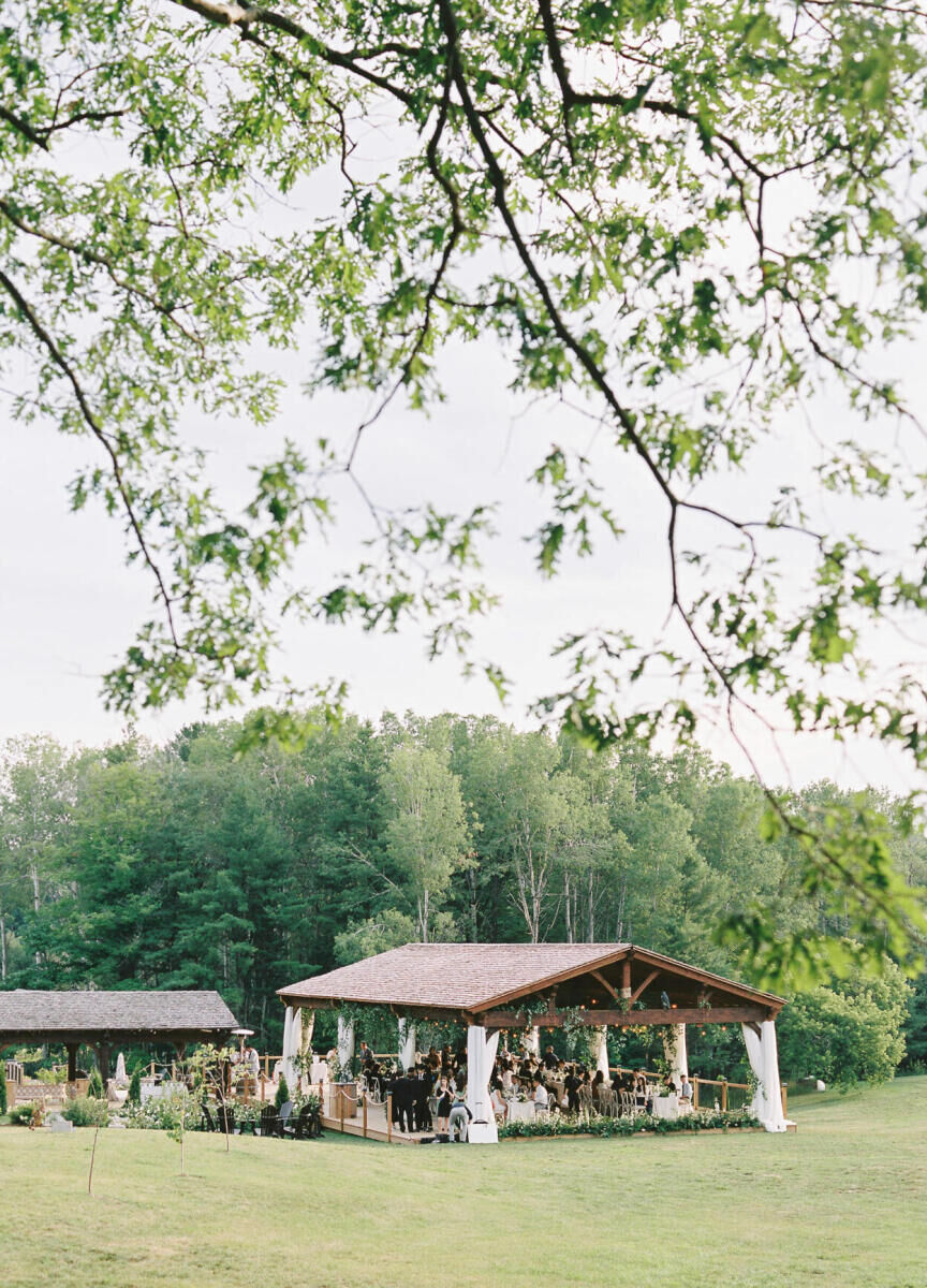 An outdoor reception that followed a forest wedding ceremony in an open structure on sprawling grounds at a venue in Canada.