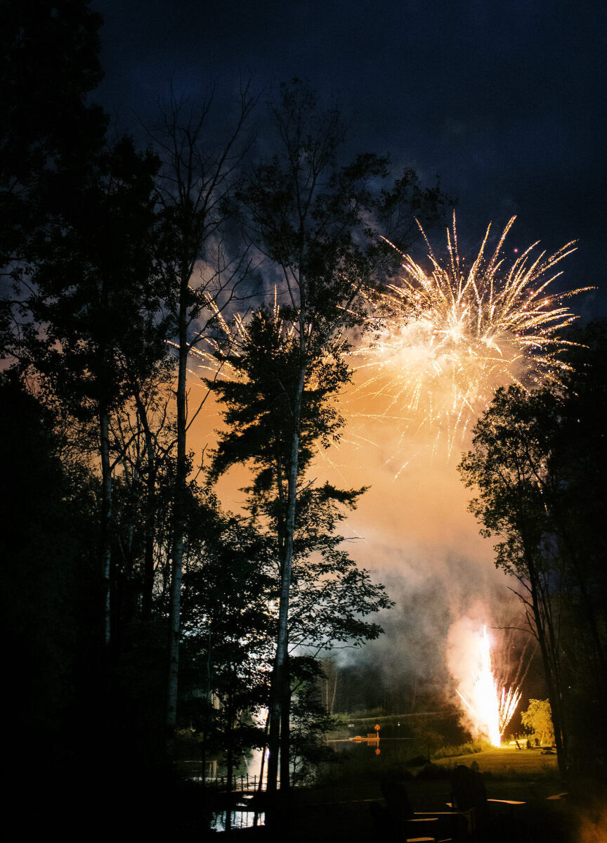A big fireworks display over the trees at a forest wedding in Canada.