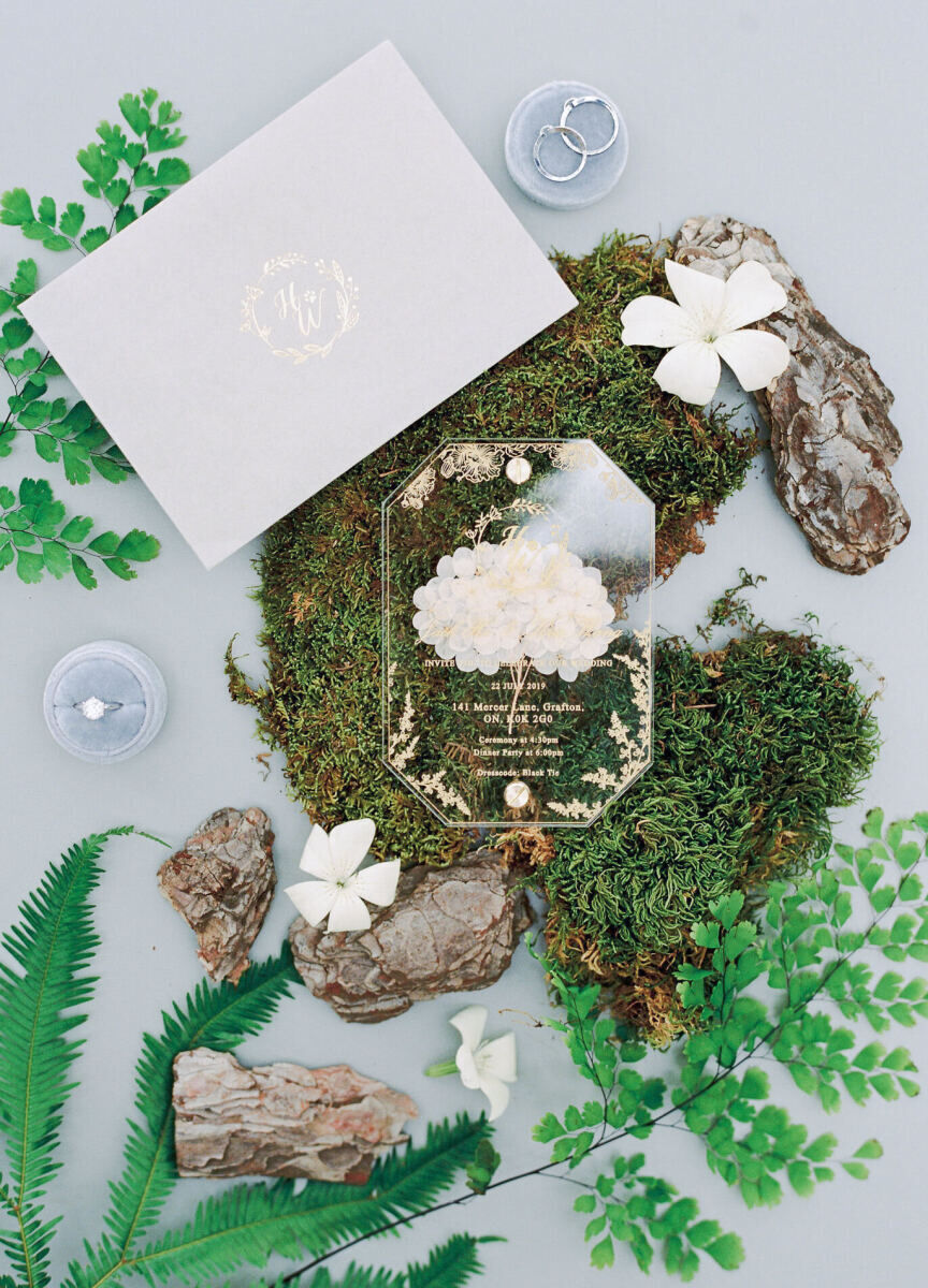 A modern invite for a forest wedding, made with clear acrylic and gold accents.