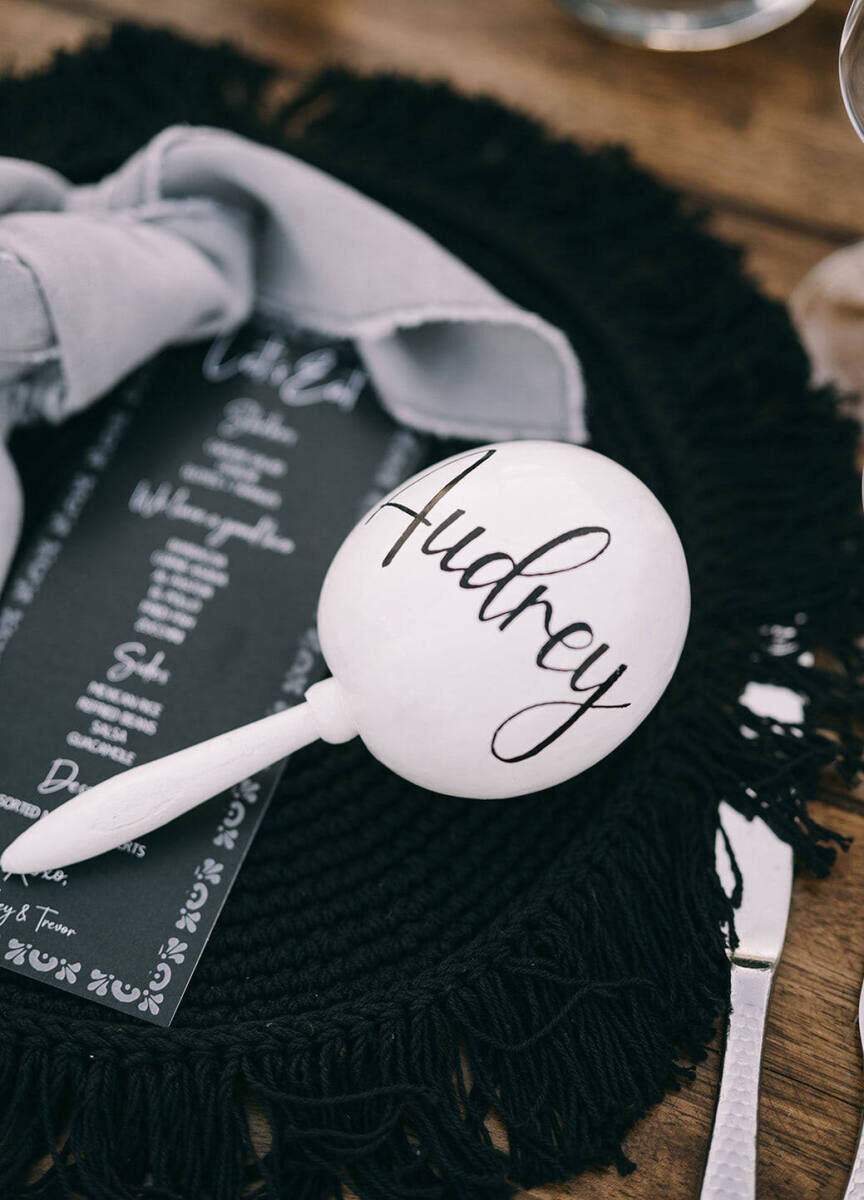 A glam beach wedding with fun accents called for calligraphed maracas at each placesetting.