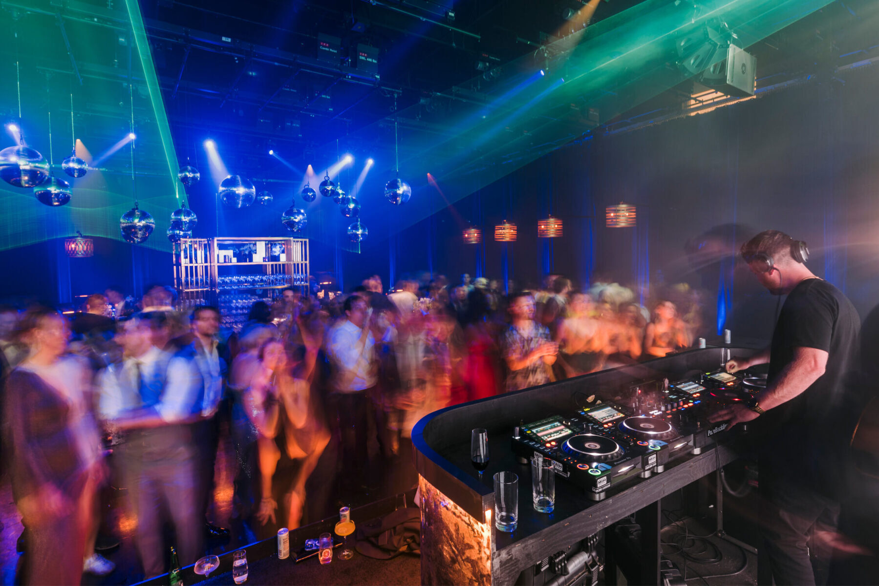 A DJ spins while guests dance at an after-party during a glam enchanted wedding.