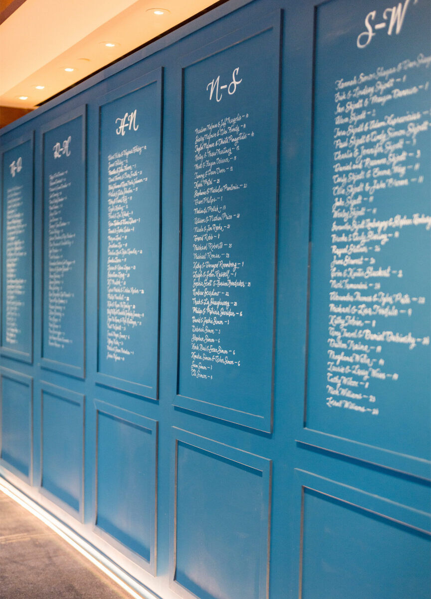 A statement wall with calligraphed names guided guests to their seats at a glam enchanted wedding.