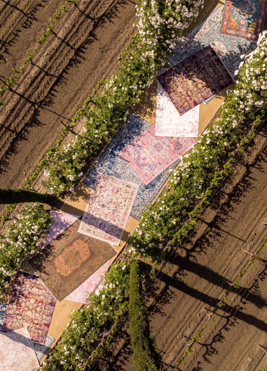 An overhead view of a rug-lined pathway at a vineyard where a glam enchanted wedding began.