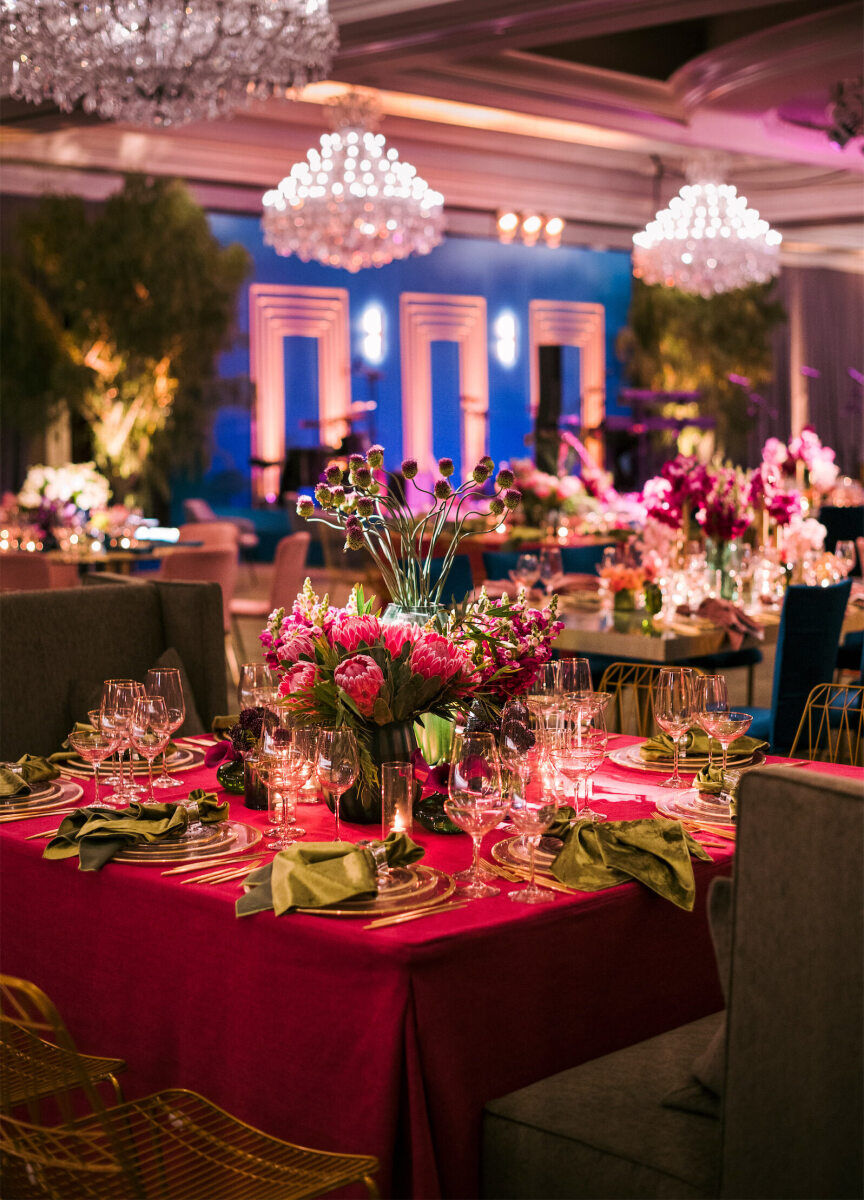 Pink, blue, and green came together in the reception design of this glam enchanted wedding in a ballroom.