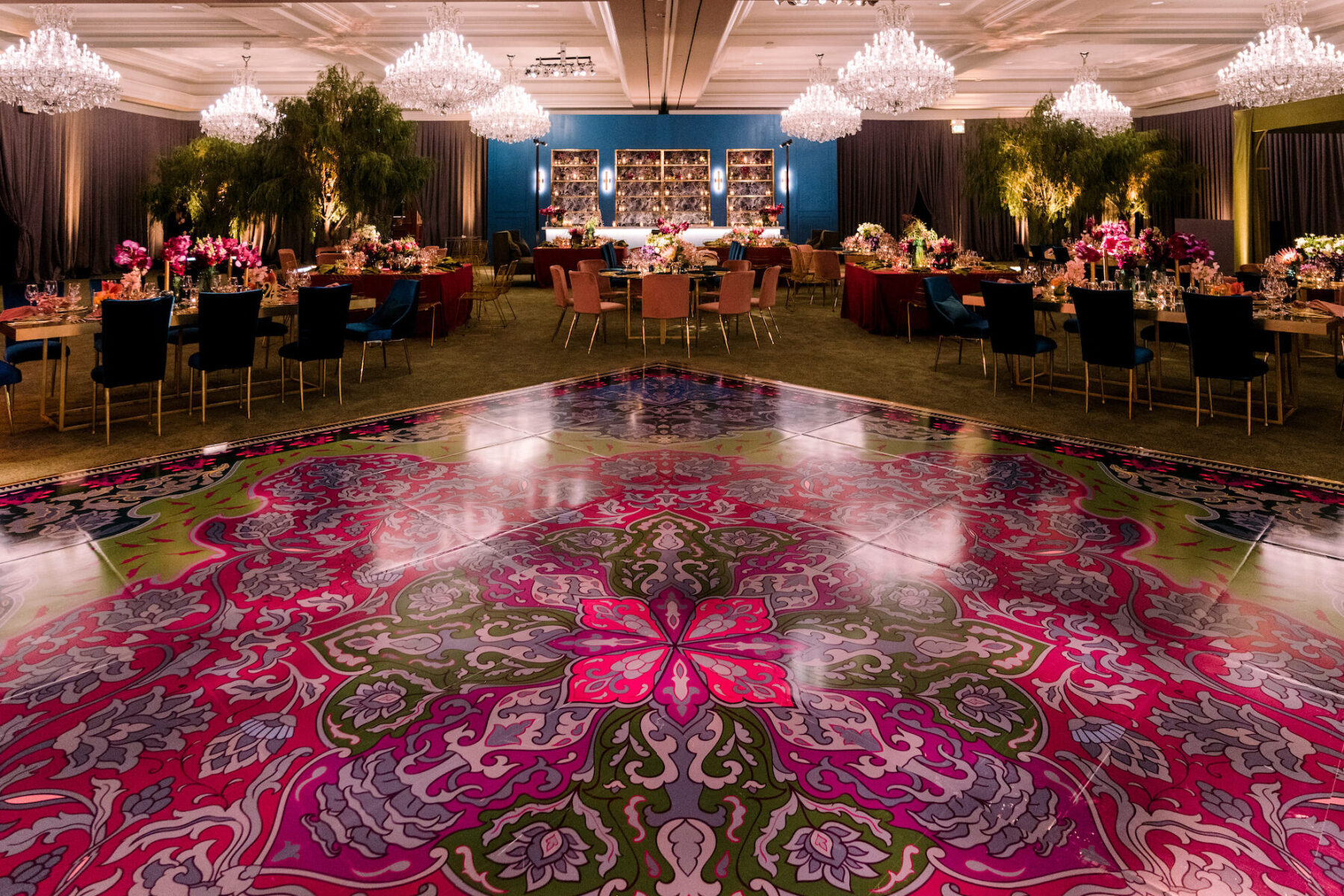 A glam enchanted wedding reception in a ballroom of a hotel in California, with a rug-inspired dancefloor and draped walls.