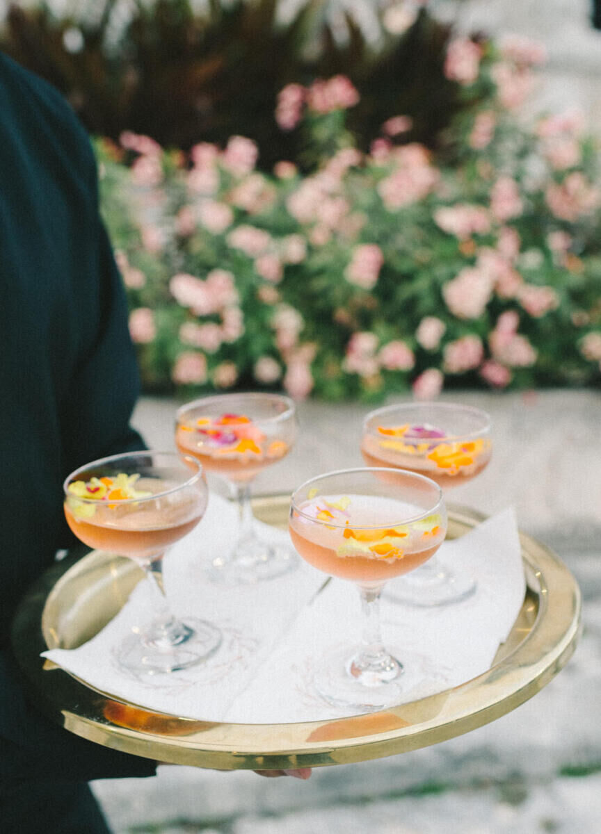 The bride's signature drink was a sparkling rosé served with an edible flower, which was fitting for her glam, garden wedding.