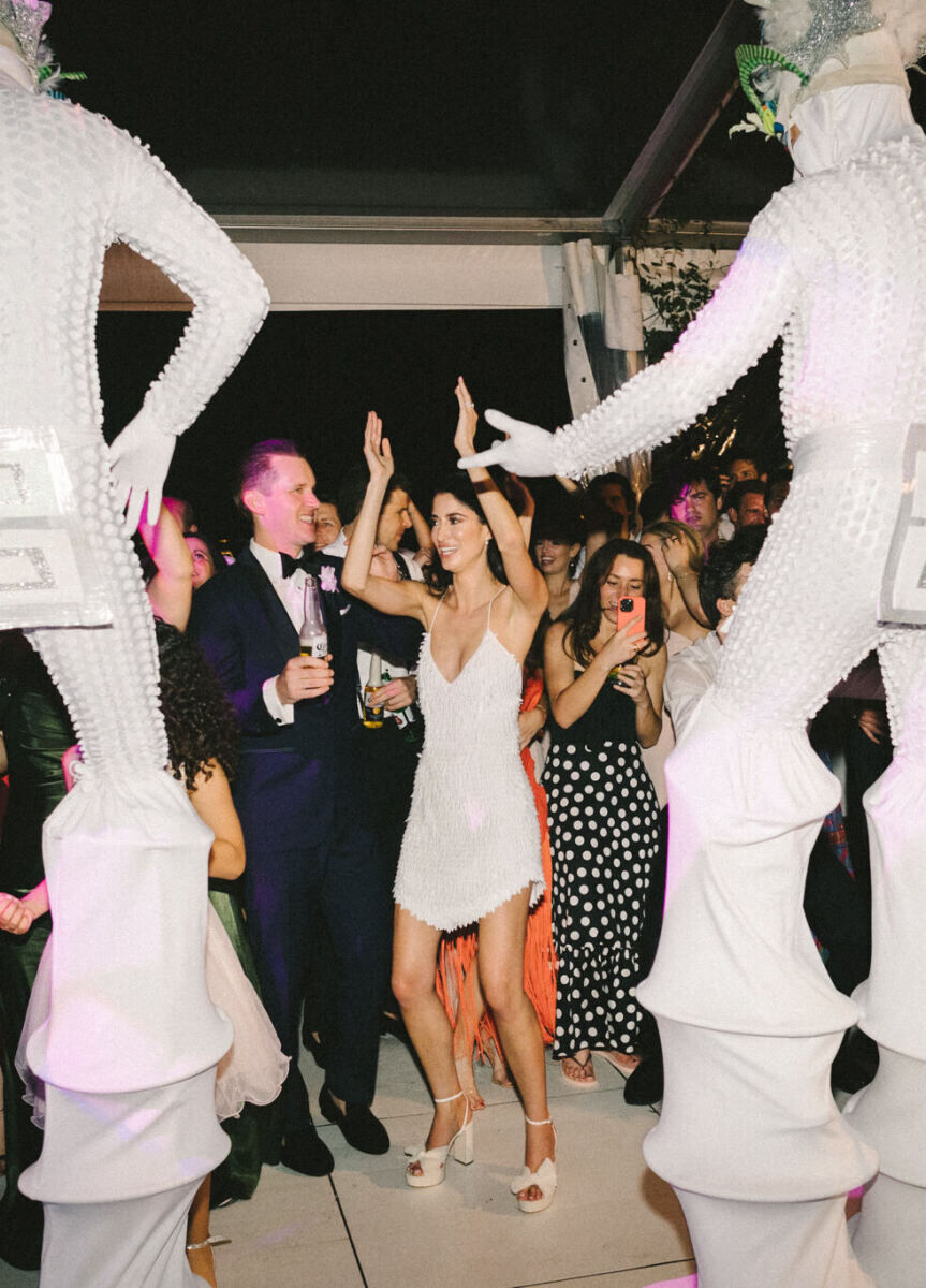 Newlyweds enjoy the performers during their hora loca at their glam, garden wedding reception.