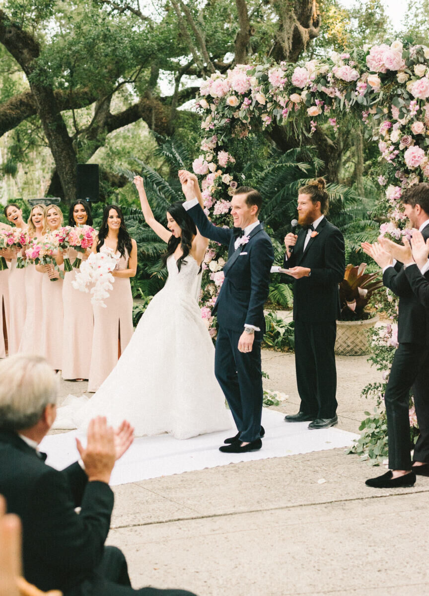 A joyful bride and groom are all smiles after getting married at their glam, garden wedding.