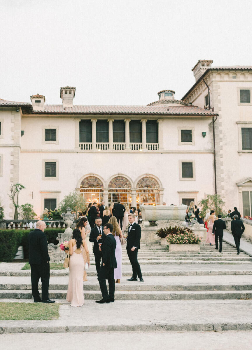 Guests enjoy cocktail hour at Vizcaya, where this glam, garden wedding took place.