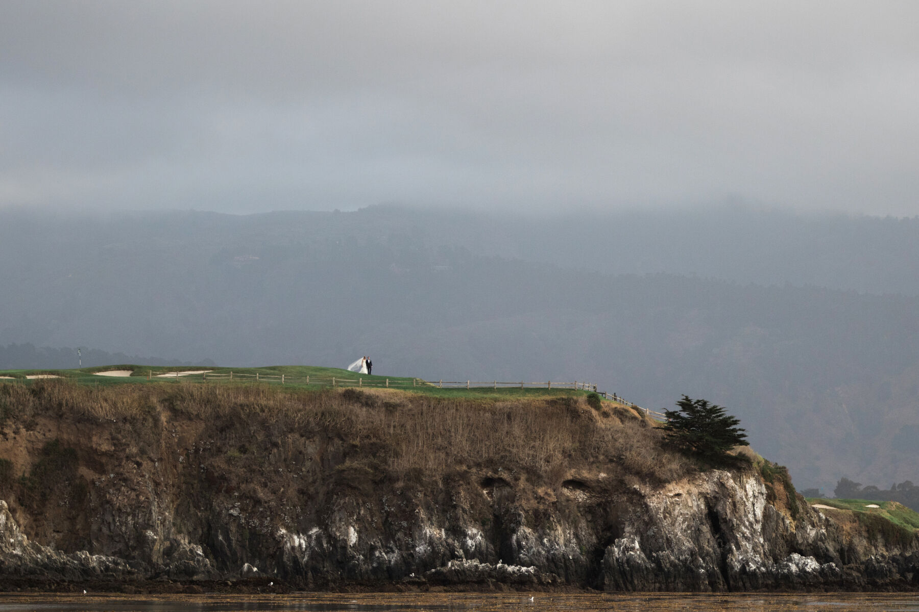 Golf Course Wedding Venues: A couple standing near a cliff on their wedding day in Northern California.