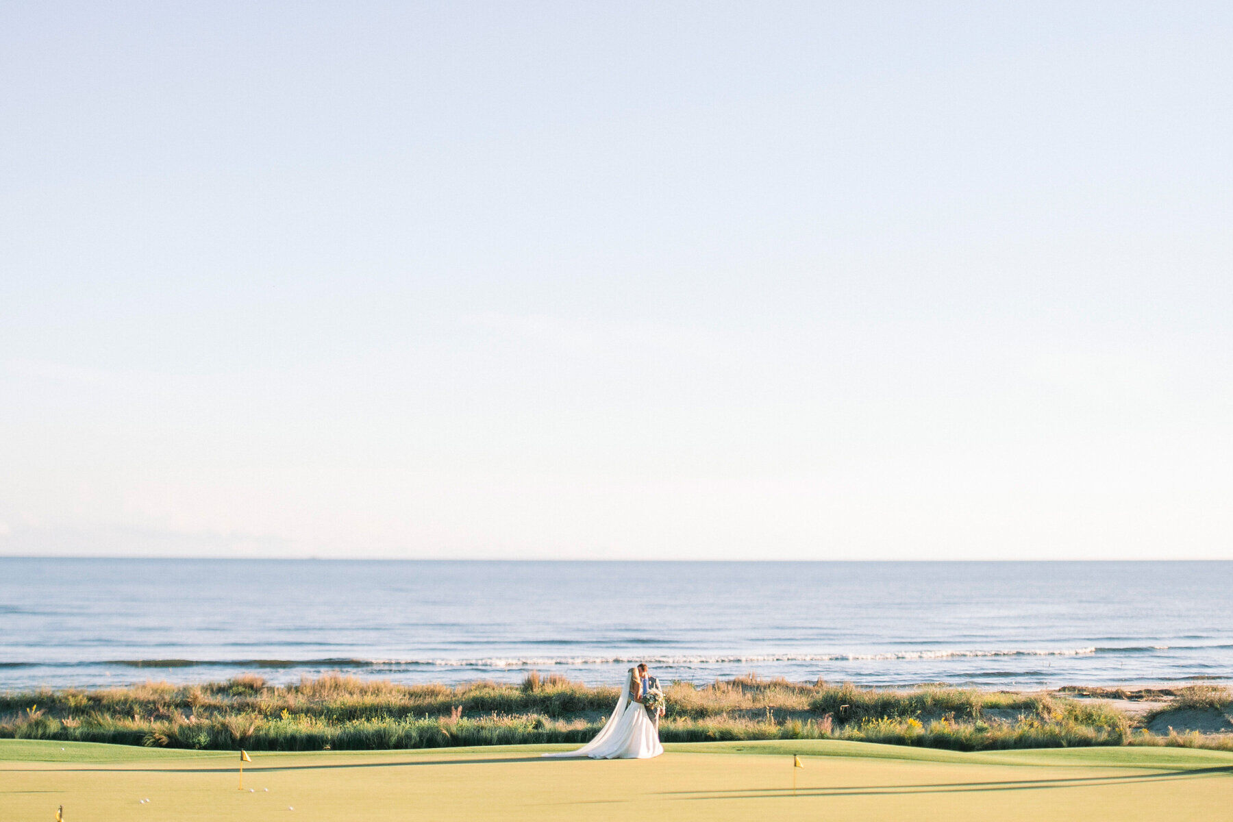 Golf Course Wedding Venues: A wedding couple on an oceanfront golf course in Kiawah Island, South Carolina.