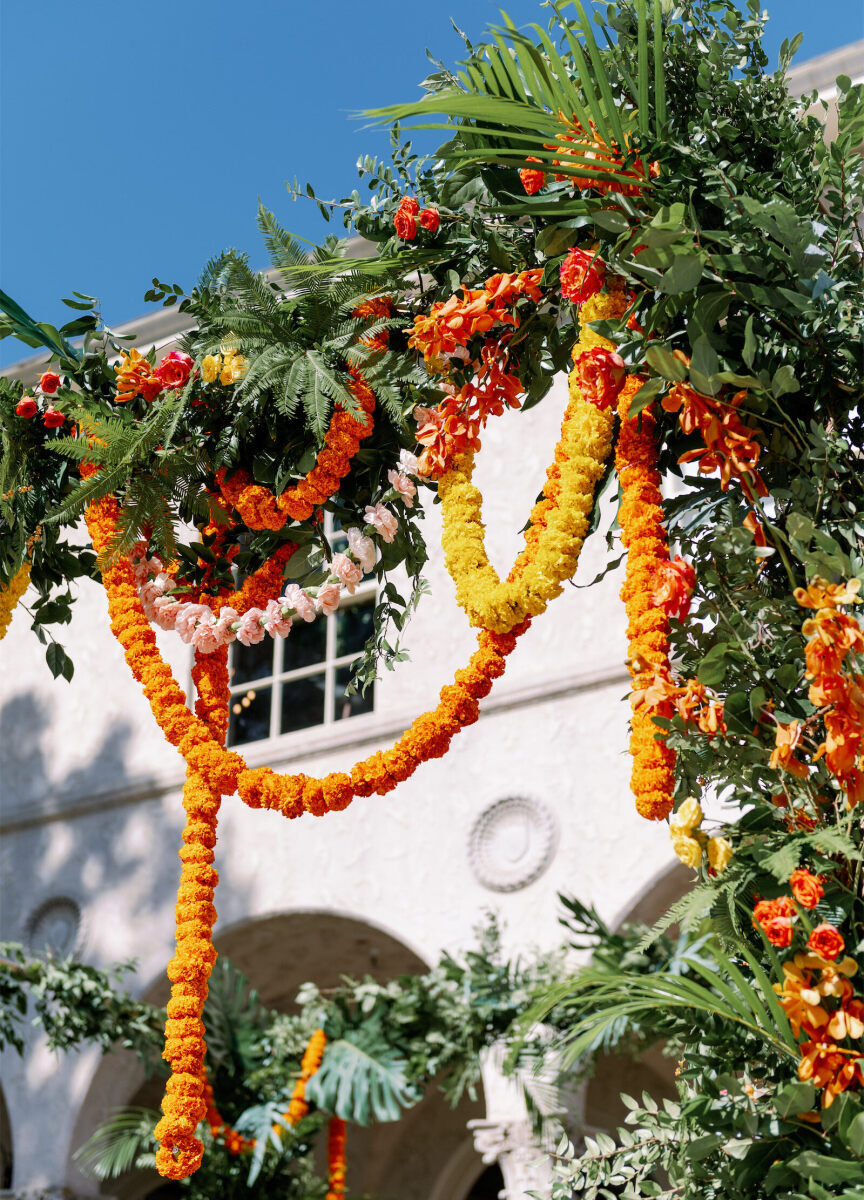 Colorful garlands hang from a large mandap at an outdoor Indian fusion wedding in Austin.
