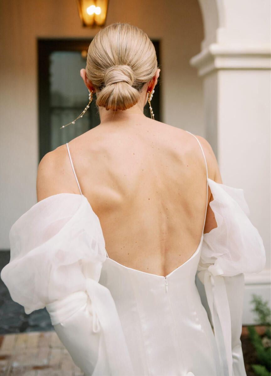 A chic, low bun was the perfect accessory for a Danielle Frankel off-the-shoulder reception dress at an Indian fusion wedding at Commodore Perry Estate.