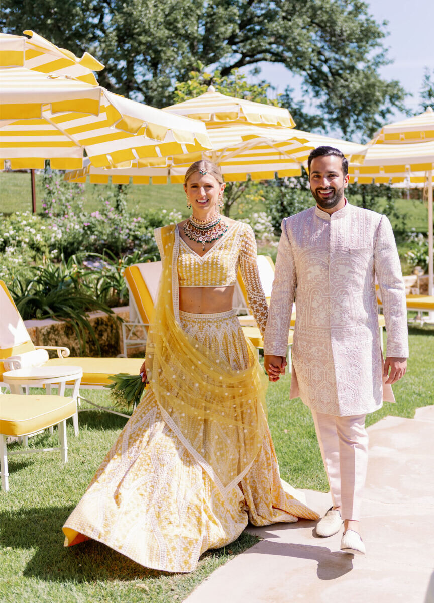 A bride and groom in shades of yellow and ivory matched the venue at their Indian fusion wedding.