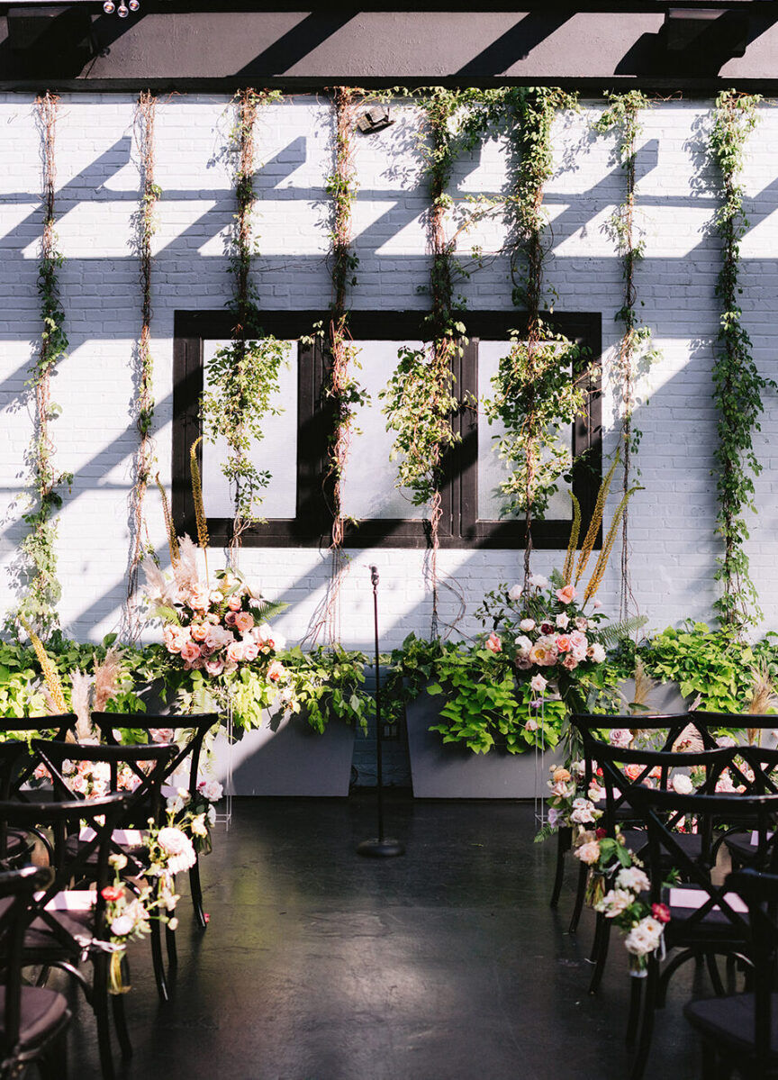 Industrial Wedding Venues: A ceremony set-up at 501 Union with hanging floral installations against.a white backdrop.