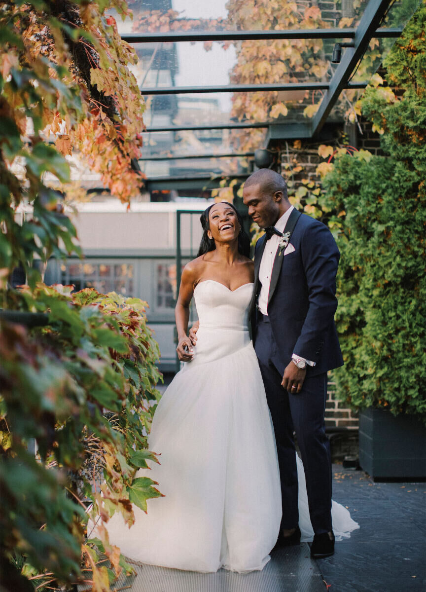 Industrial Wedding Venues: A bride and groom laughing, surrounded by greenery.