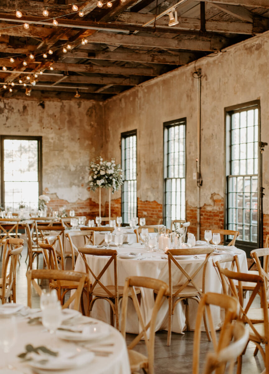 Industrial Wedding Venues: A reception set-up with many round tables and wooden chairs in an industrial-inspired great room in Mt. Washington Mill Dye House.