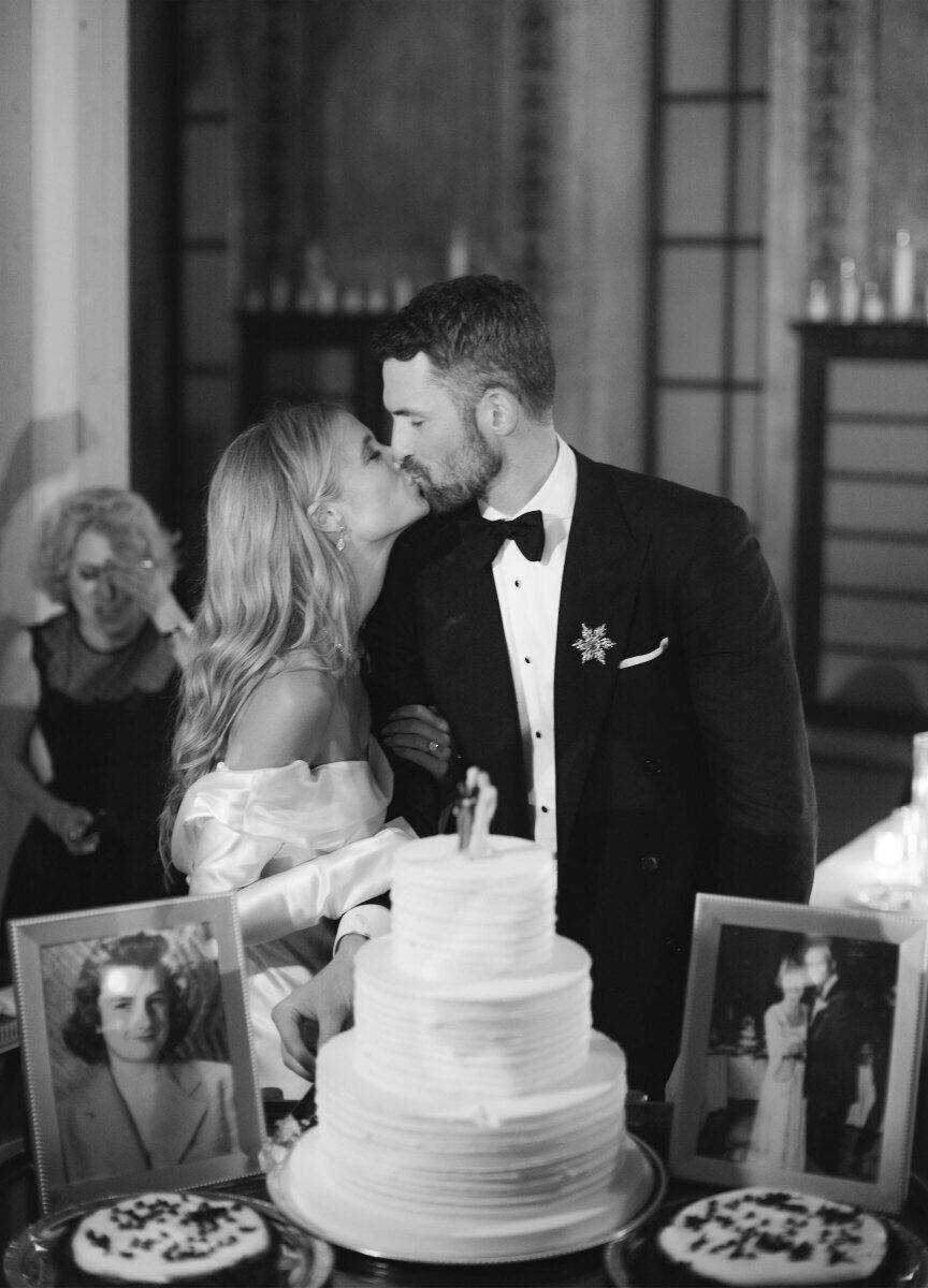 Kate Bock Kevin Love Wedding: Kevin Love and Kate Bock sharing a kiss in at their wedding dessert table.