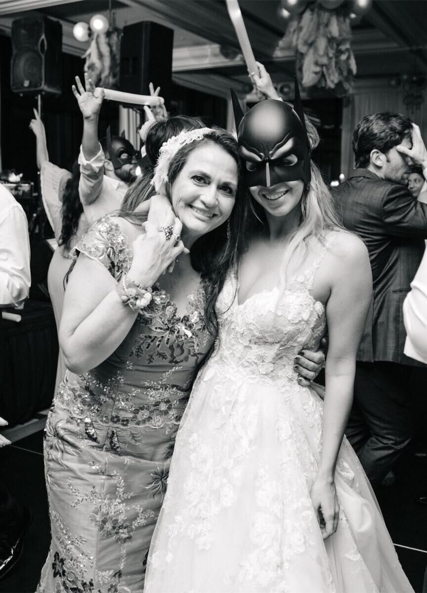 Latinx Heritage: A bride passing to take picture with her mother while dancing during the crazy hour (la hora loca) at their wedding.