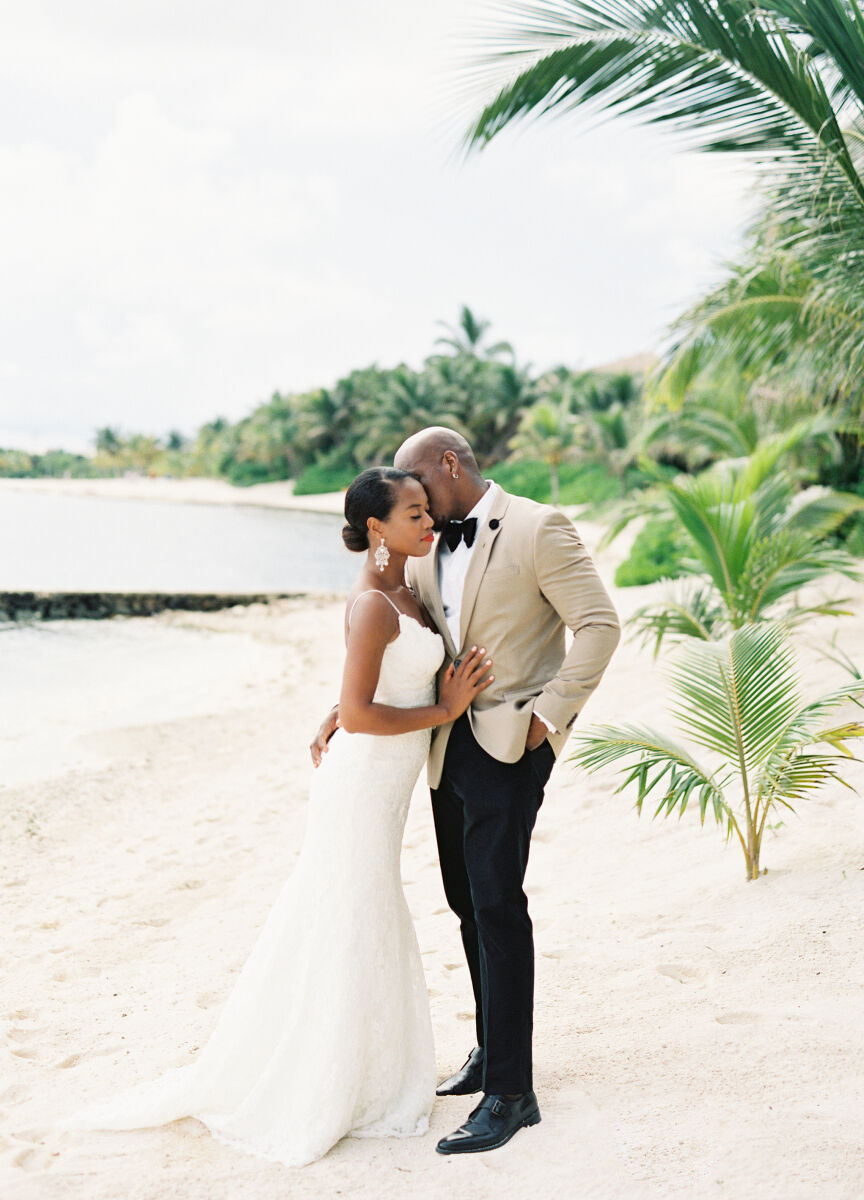 Wedding Cost Surprises: A groom kissing a bride in a portrait on the beach.