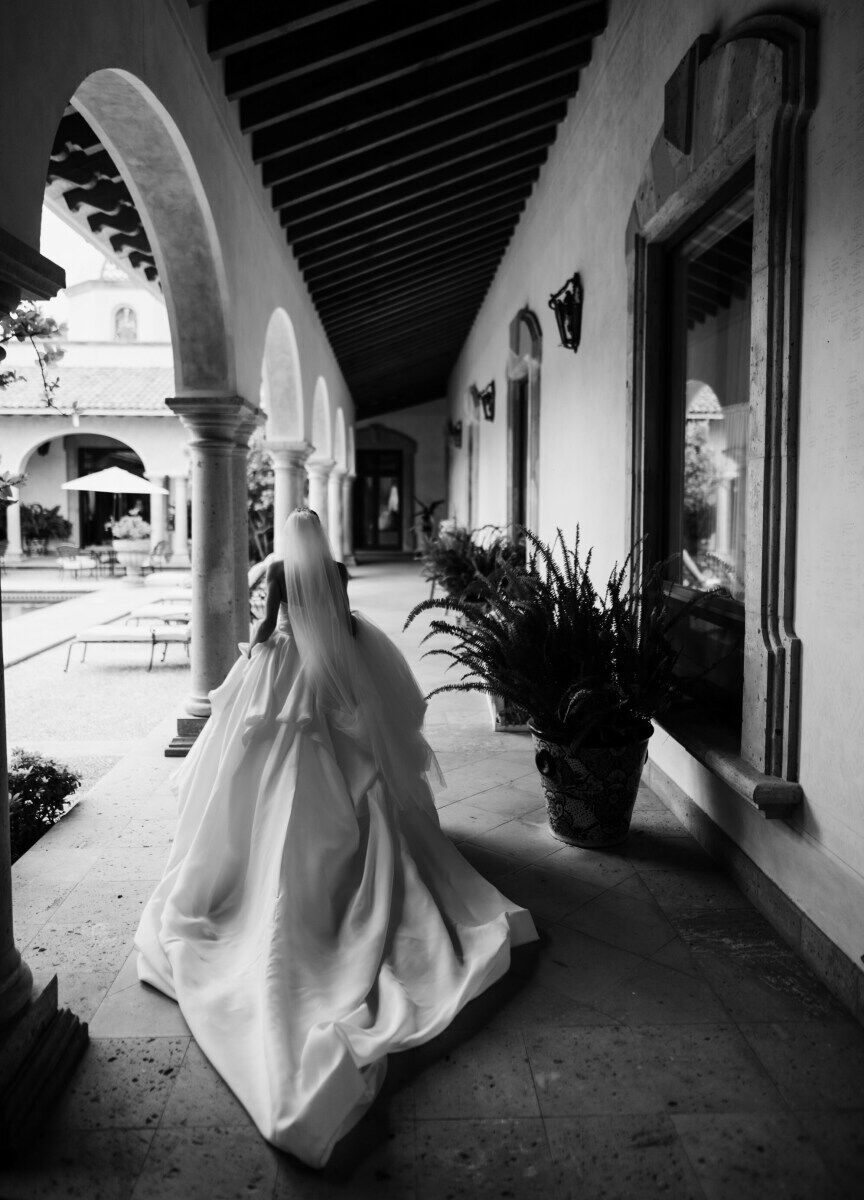 Mexican wedding: bride walking down outdoor corridor at an estate style wedding venue