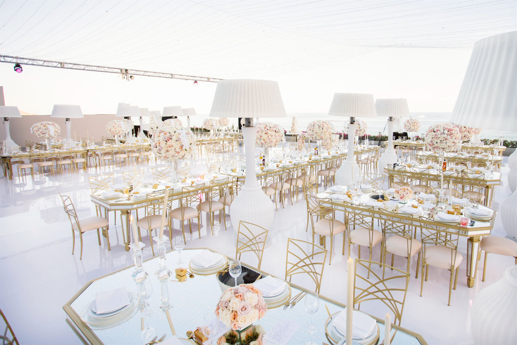 Mexican wedding: white and gold wedding reception outside on the beach