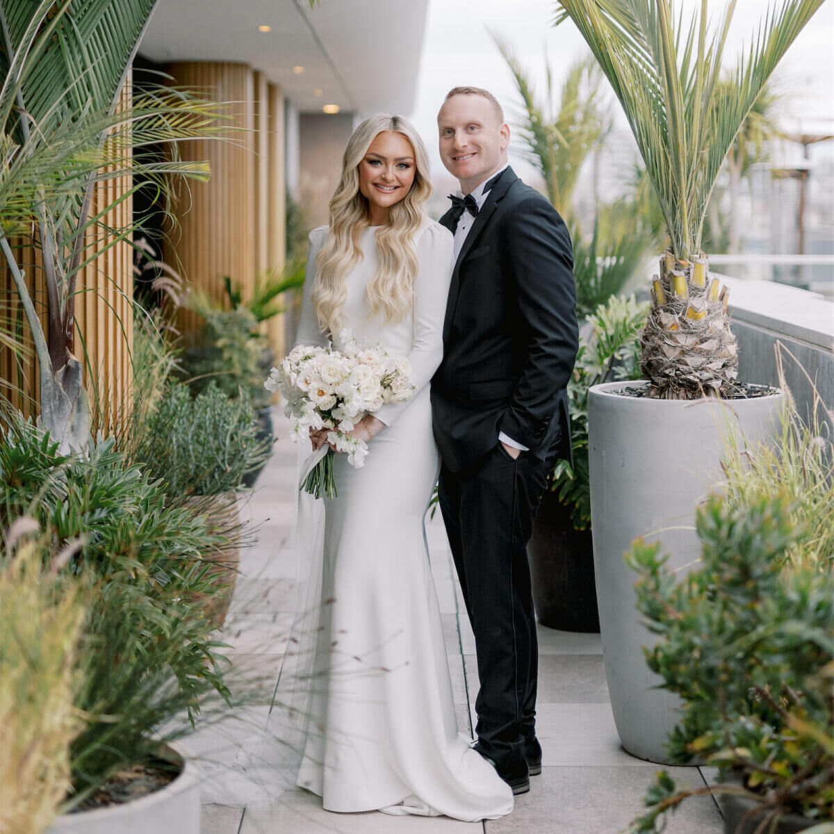 A bride and groom smile while having their portrait taken during their modern California wedding at the Santa Monica Proper hotel.