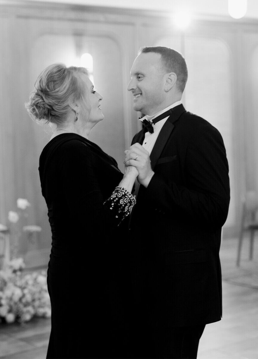 A groom and his mother share a dance during the reception of his modern California wedding.