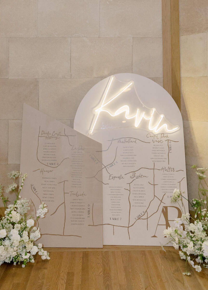 The seating chart at a modern California wedding incorporated neon spelling out their newly shared last name, and was a spin on a map, outlining seating assignments by table, with each table named for a street with significance to the couple.