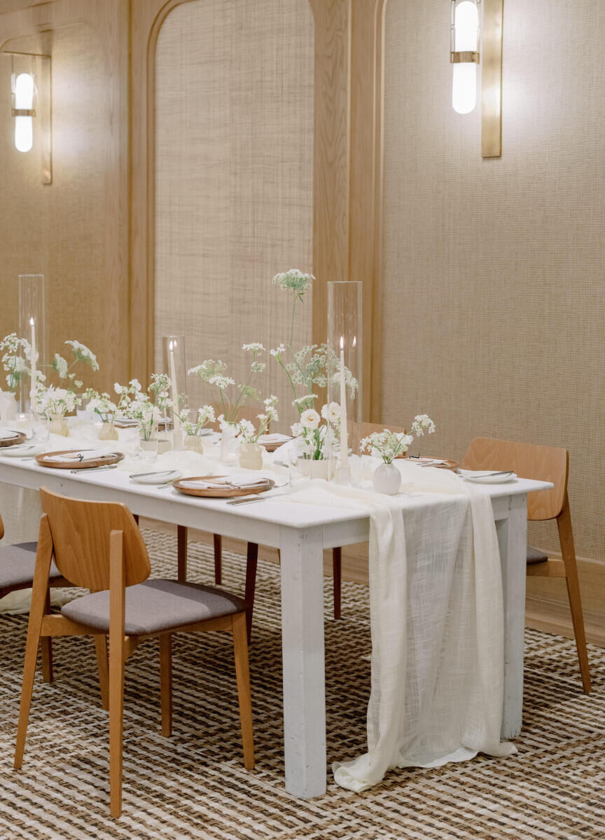 A modern California wedding reception, with a gauzy table runner, wood chairs, and minimal centerpieces.
