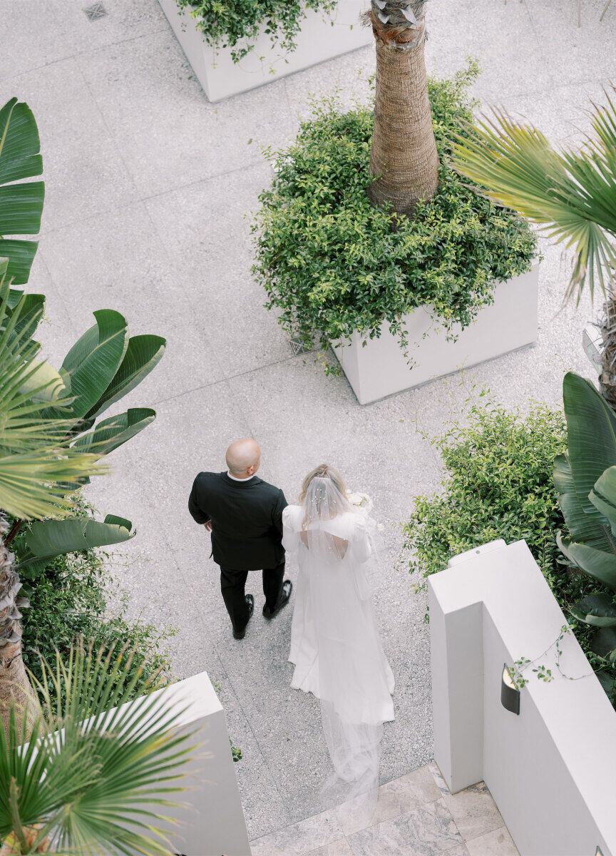 An overhead look at a bride and her father about to walk down the aisle at her modern California wedding ceremony.