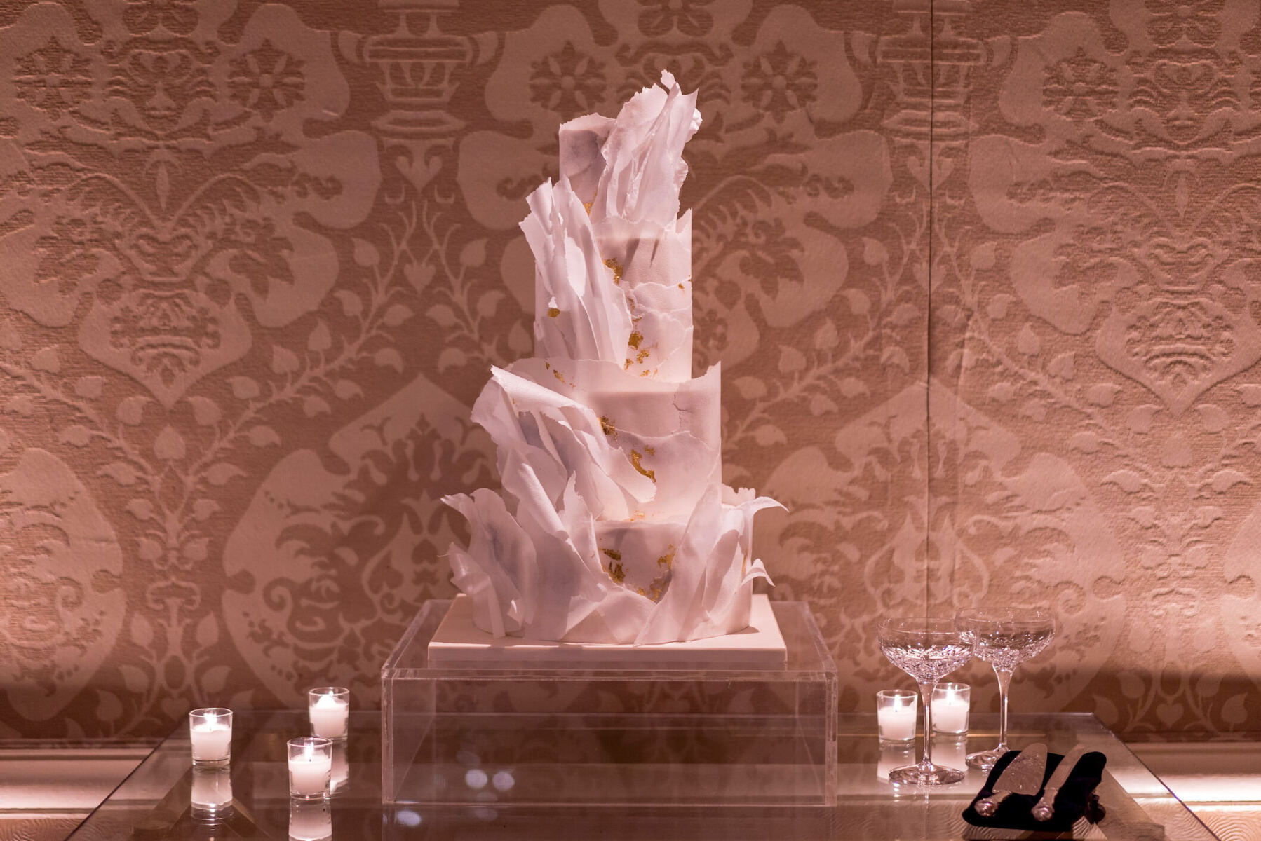 A modern wedding cake with torn wafer paper and edible gold leaf.