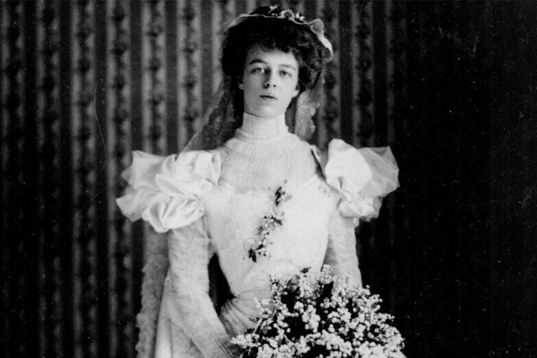Most Influential Women in History Weddings: Former First Lady Eleanor Roosevelt posing in her wedding dress with a cascading bouquet 