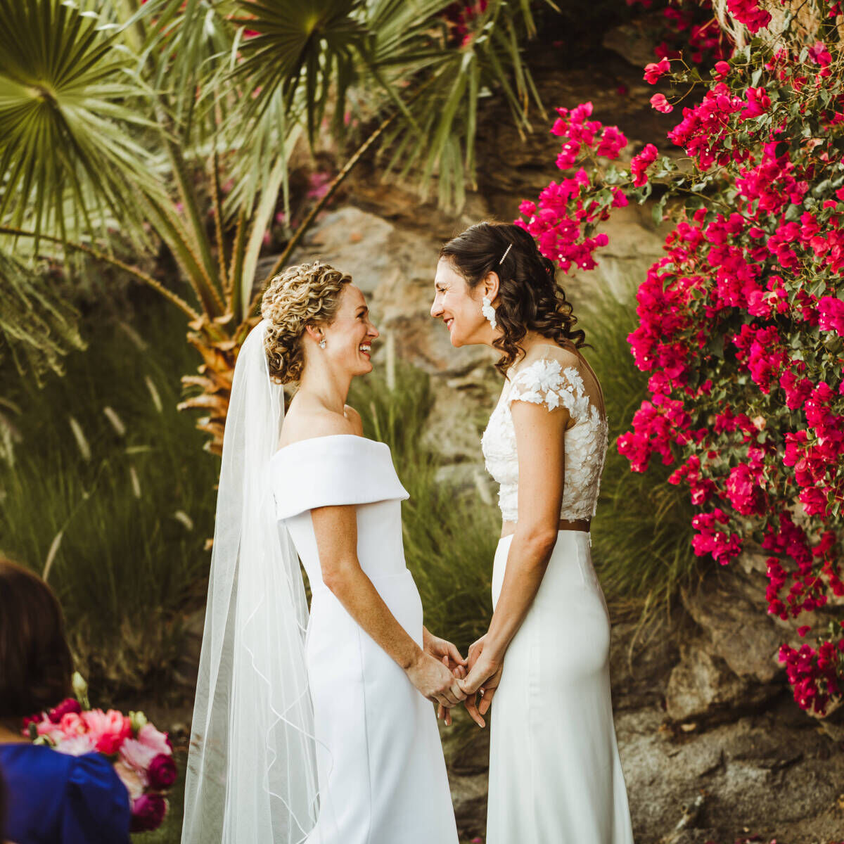 Pink Wedding: Two brides gazing into each other's eyes at their wedding ceremony.
