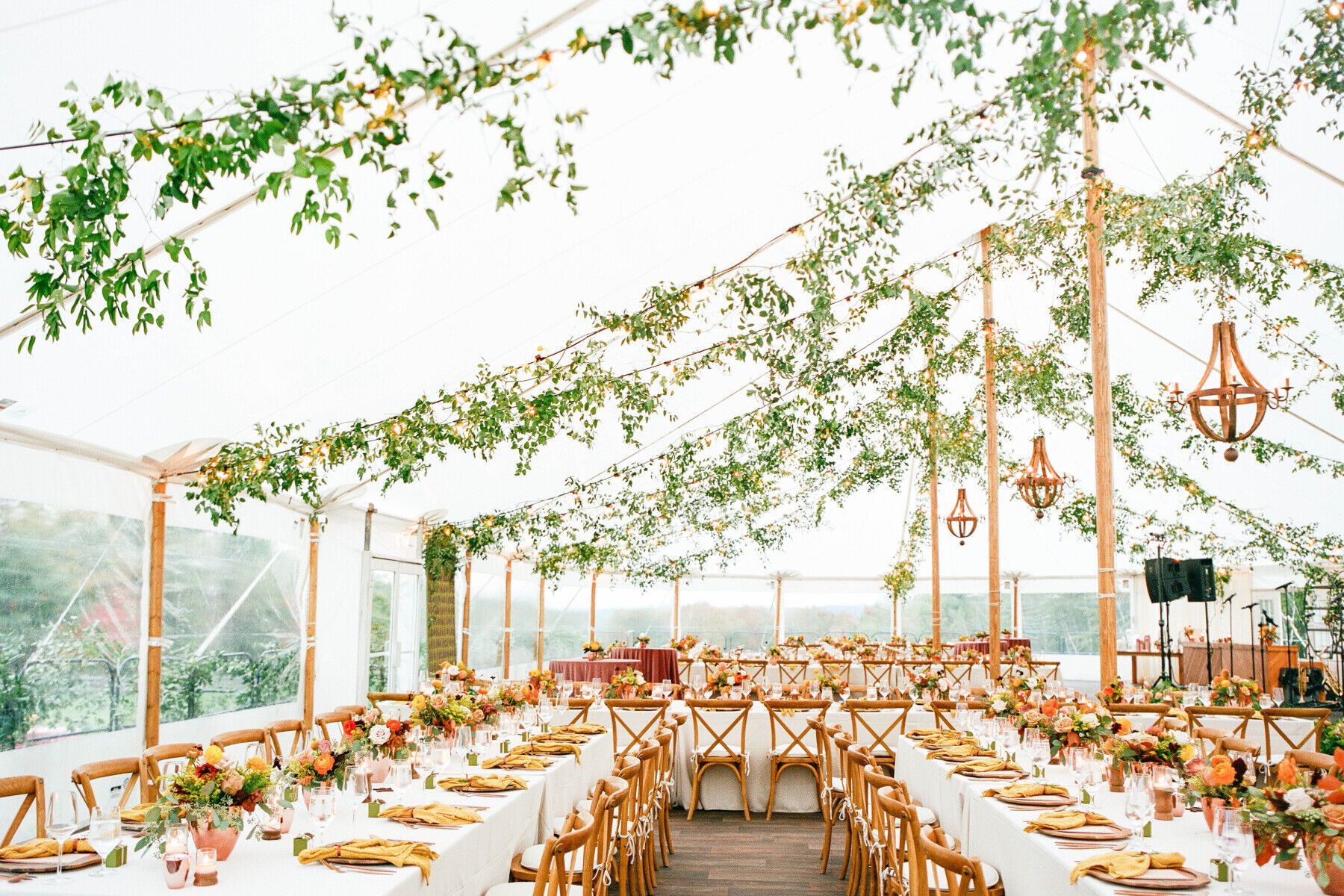 Tented Wedding Ideas: Inside of a tented wedding reception, bright white tent with foliage ceiling decor