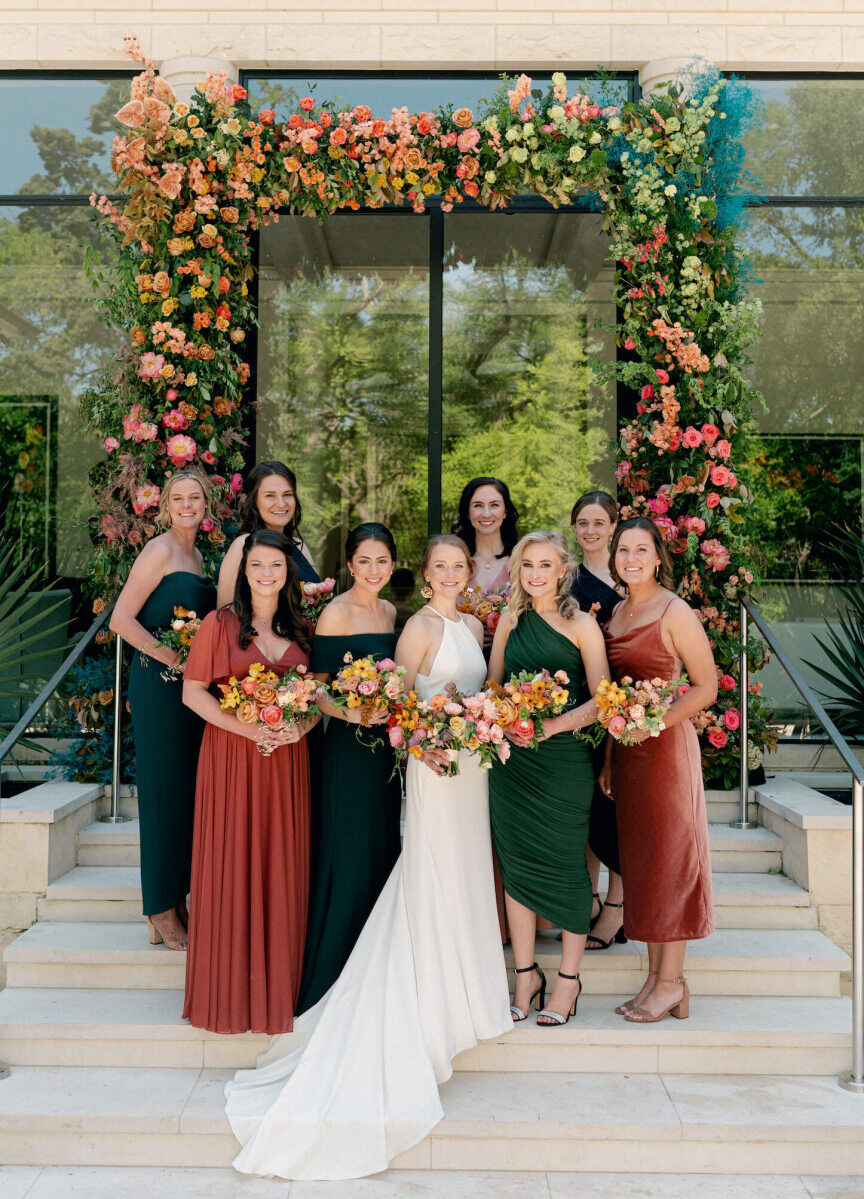 For this rainbow wedding, bridesmaids wore various green and pink dresses and carried colorful bouquets, that matched the ceremony arch.