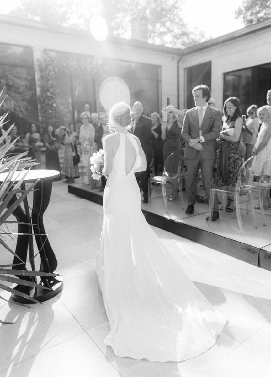 A bride walks down the aisle during her outdoor ceremony in her parents' backyard in Texas.