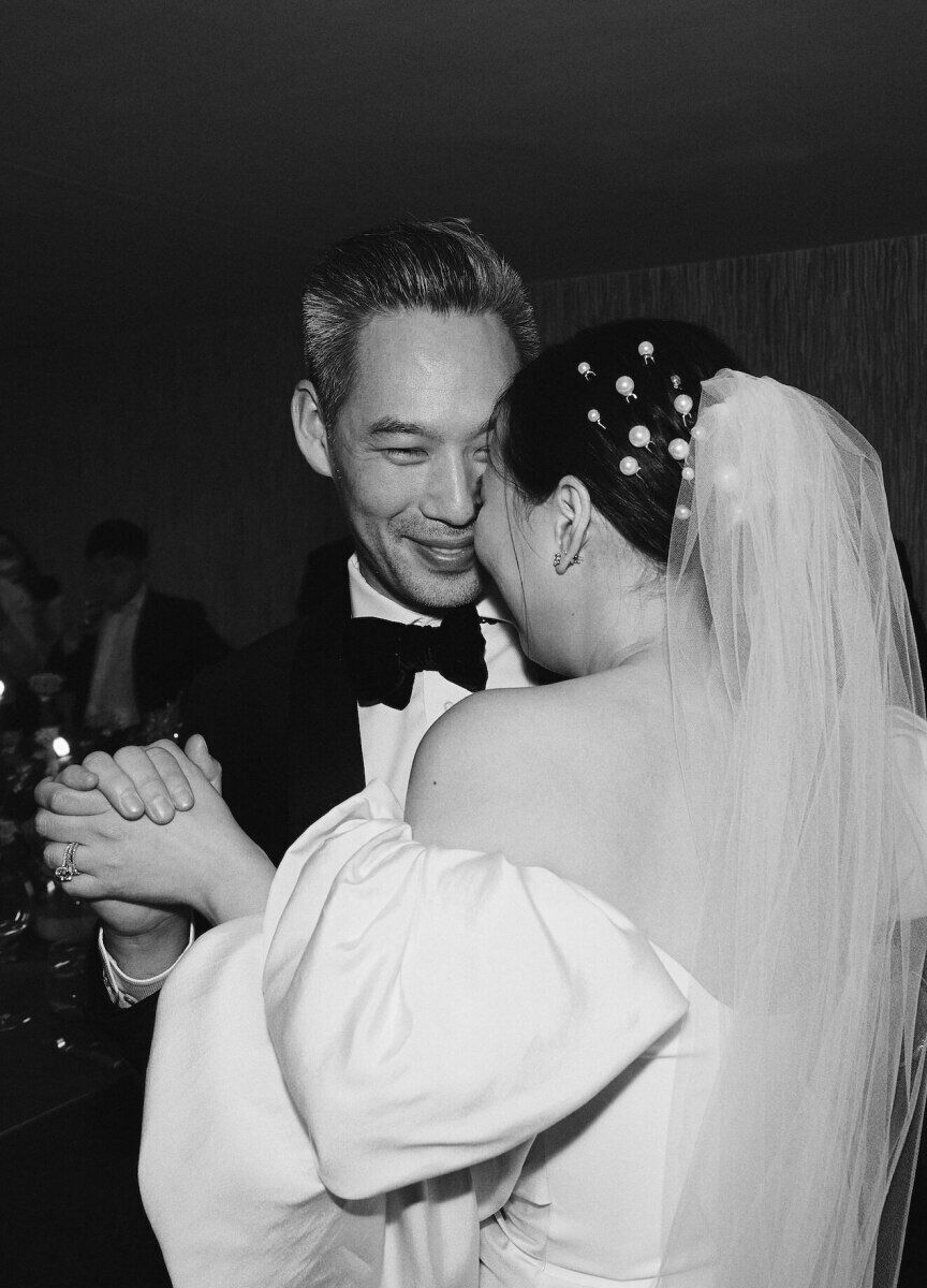 Newlyweds smile as their share an impromptu first dance during their restaurant wedding reception.