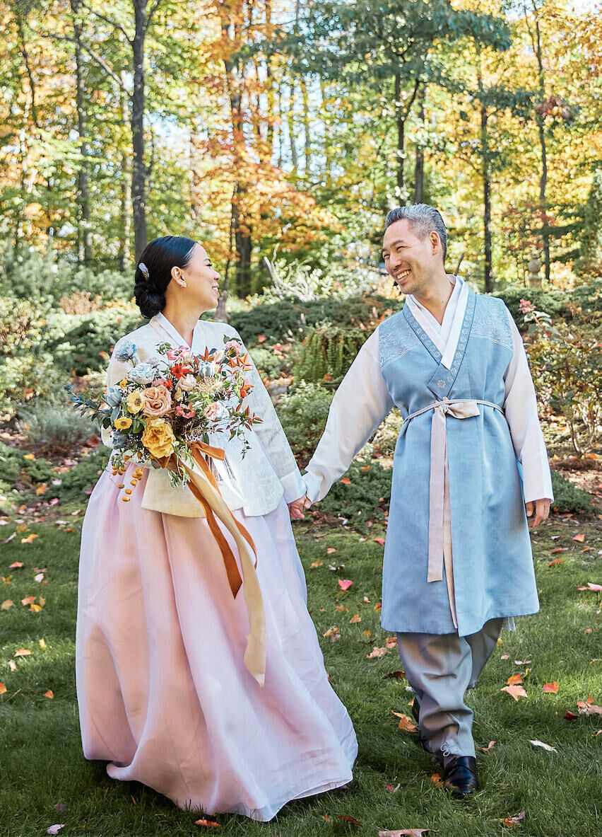 A couple takes portraits in their hanboks between their traditional Pyebaek ceremony and their restaurant wedding reception.