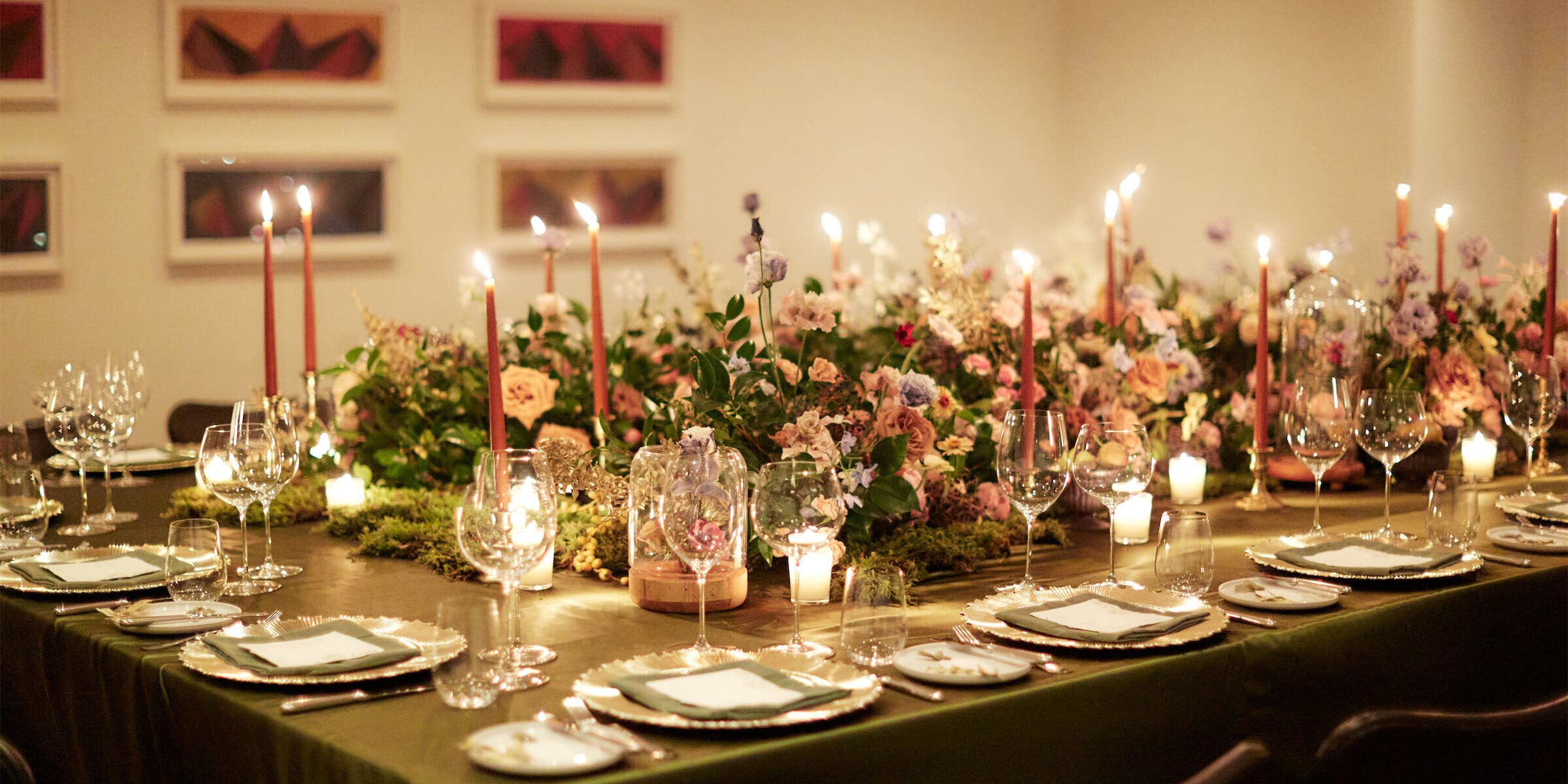 For this restaurant wedding, one long table held all the guests and was decorated with candles, moss, fresh flowers, and fresh fruit.