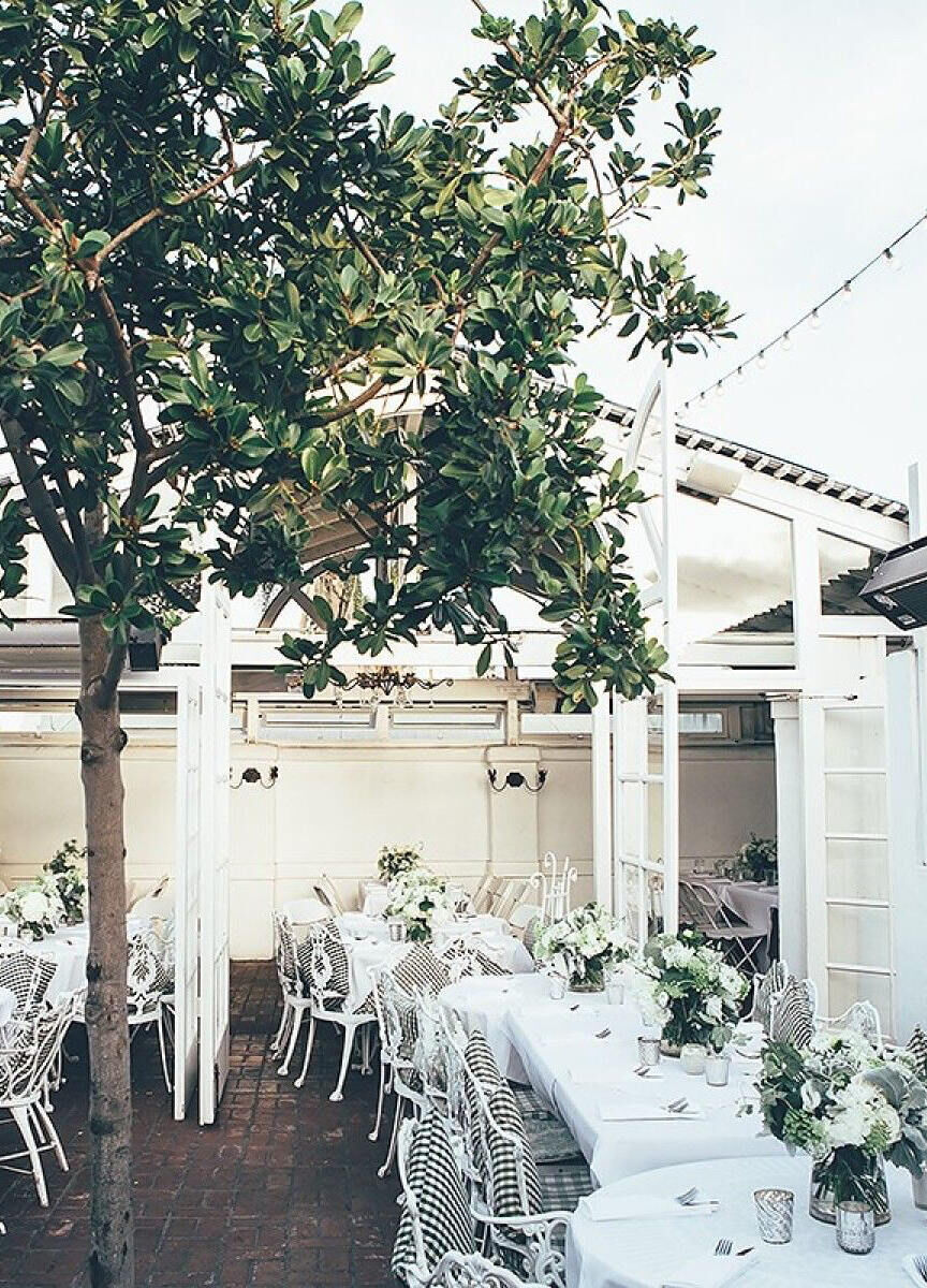 Restaurant Weddings: An outdoor reception set-up with white tables and chairs at Old Venice Restaurant.