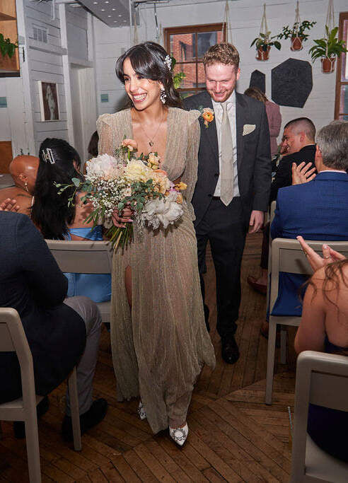 Restaurant Weddings: Smiling newlyweds walking back down the aisle together at Sunday in Brooklyn.