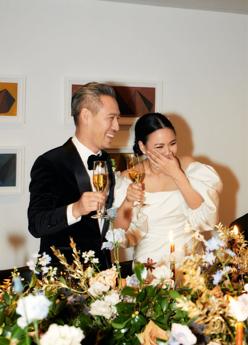 Restaurant Weddings: A bride and groom smiling and toasting their drinks in Eleven Madison Park.