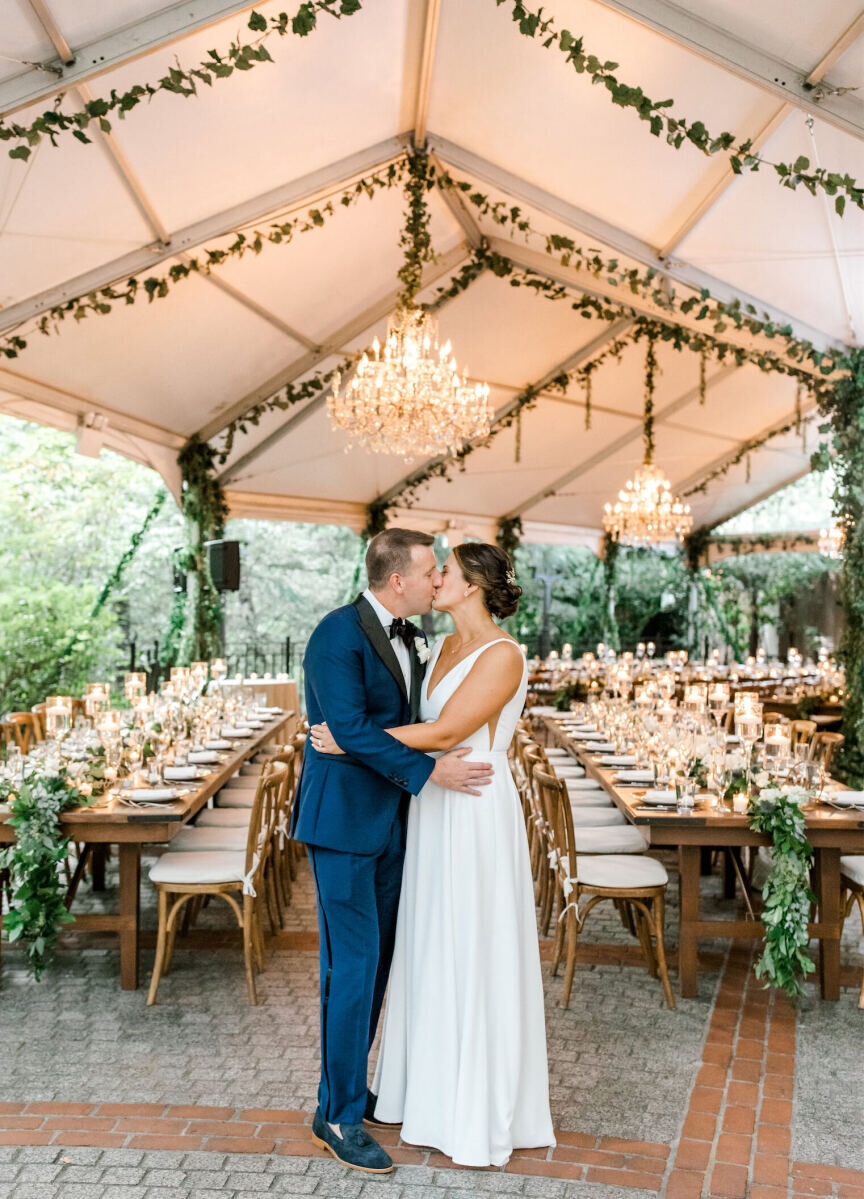 Restaurant Weddings: A bride and groom kissing in front of their outdoor tented reception set-up at Tavern on the Green.