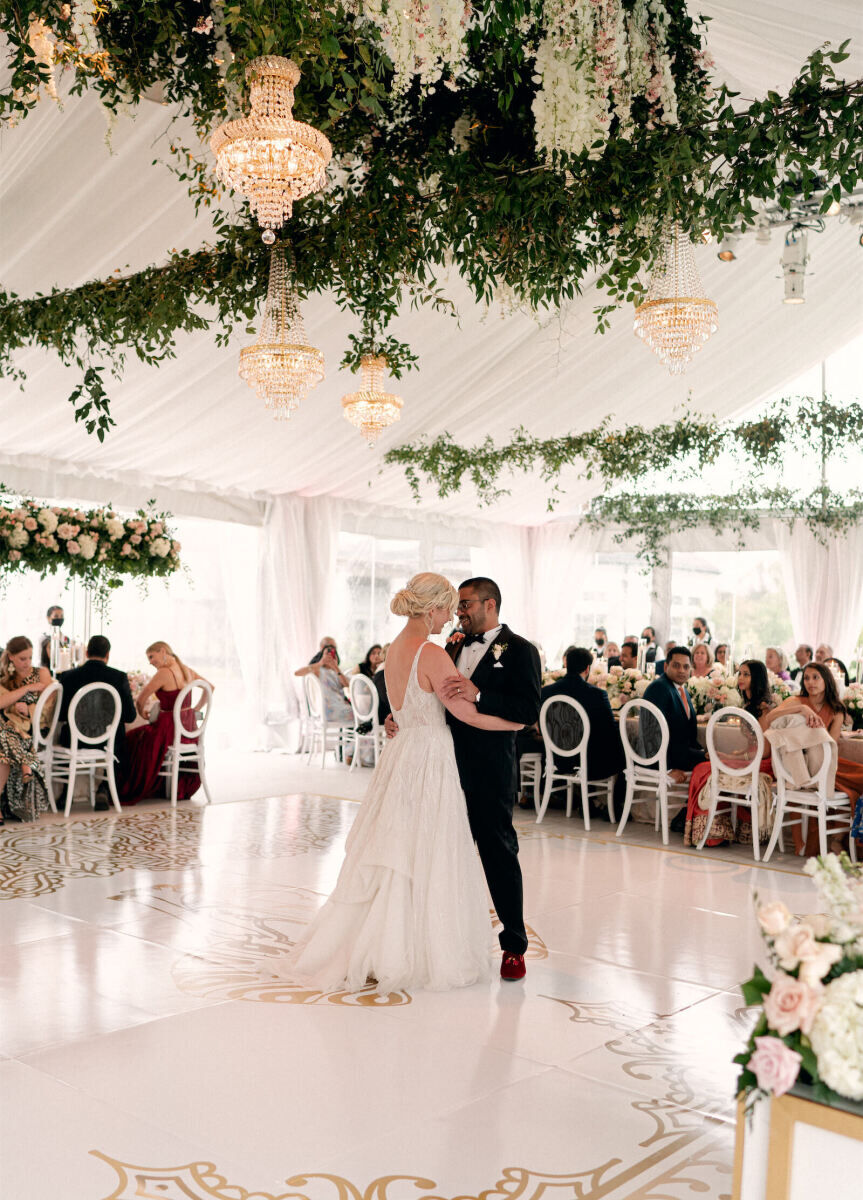 Tented Wedding: A bride and groom share their first dance on a custom dance floor at their tented wedding reception.