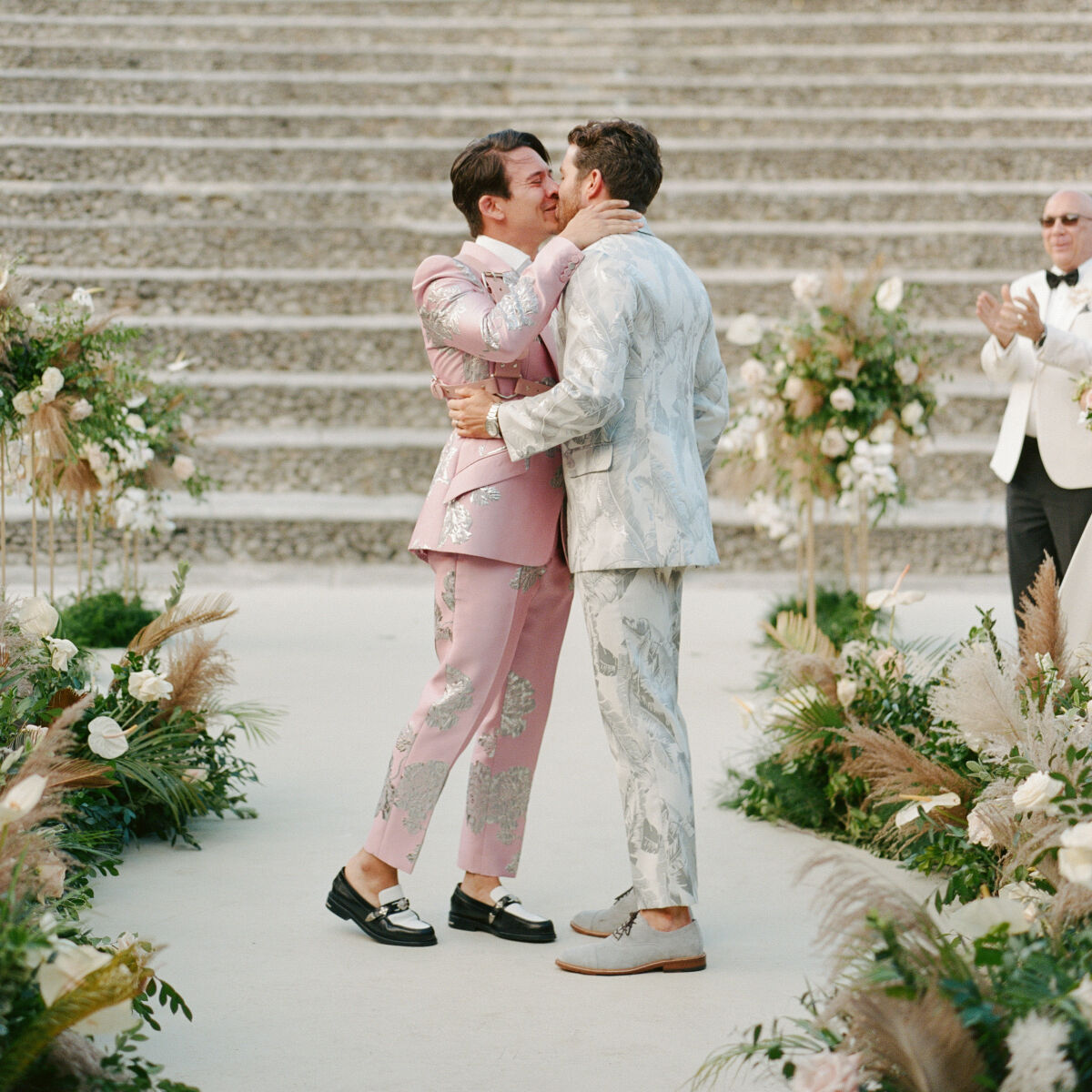 Tropical Wedding: Two grooms share a kiss at their wedding ceremony.